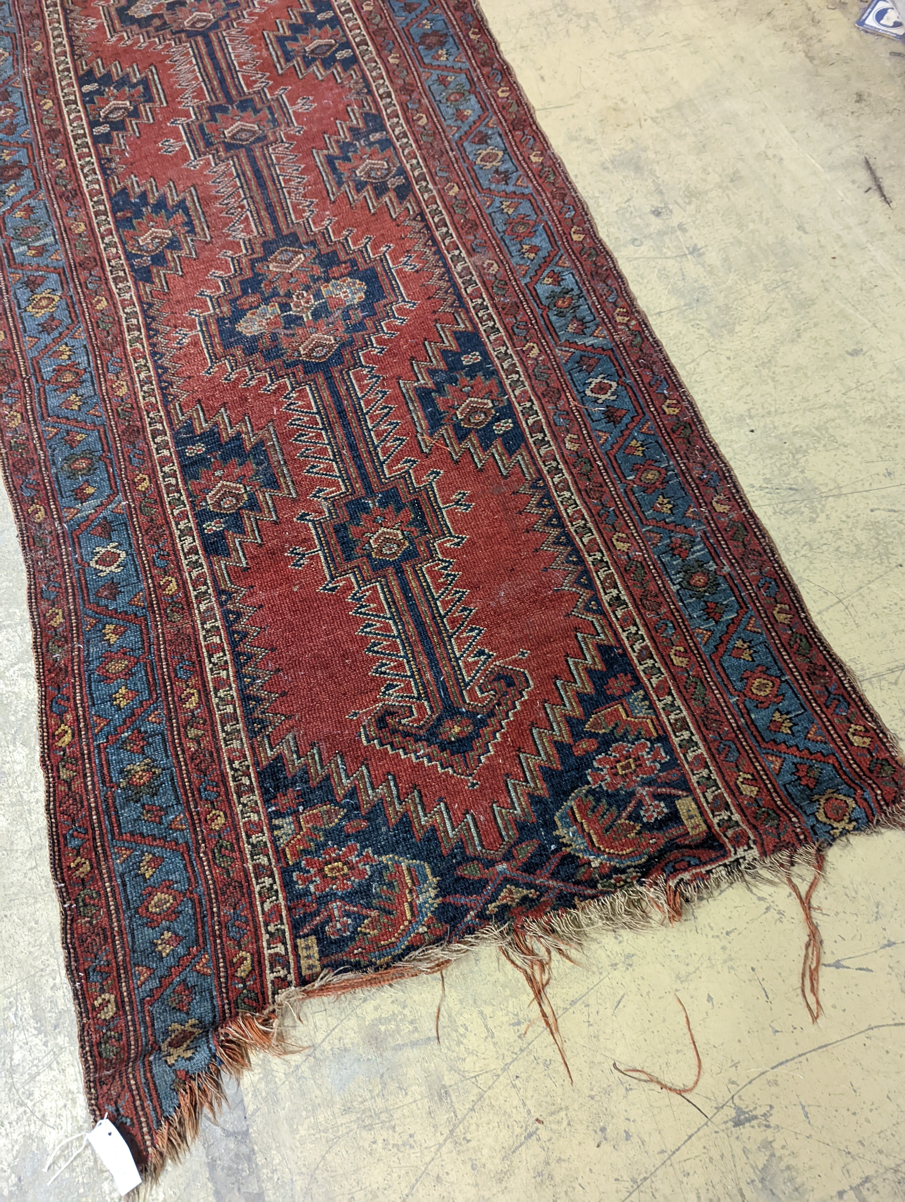 An antique Caucasian red ground runner, 380 x 100cm